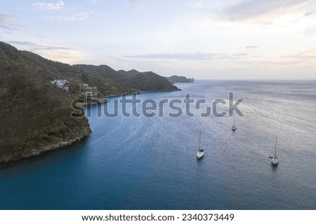 Ocean with sailboat at sunset Taganga Santa Marta Royalty-Free Stock Photo #2340373449