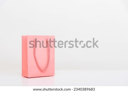 A Pink Paper Shopping Bag on White table isolated on white background