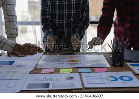 Startup entrepreneurs are discussing brainstorming together, a new start-up project in an alliance's business meeting with graphed documents while sitting at the office together. Remote Picture