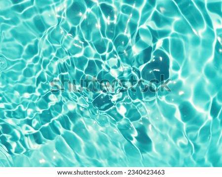 Closeup​ abstract​ of​ surface​ blue​ water​ for​ background. Reflection​ on surface​ swimming​ pool​ for​ background. Water​ splash​ for​ graphic​ design.