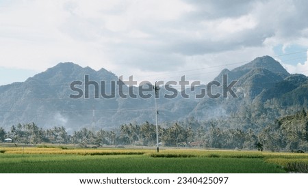 Payakumbuh, West Sumatera, Indonesia on December 23, 2021: Views of rice fields and stacked mountains beside the road to Payakumbuh.