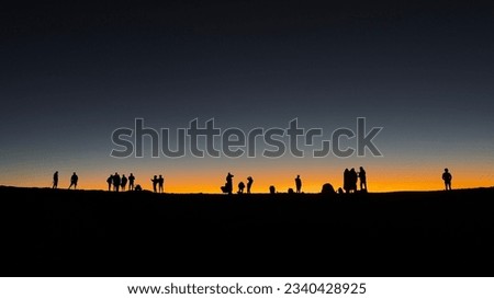 Silhouettes of people at sunset at the top of Haleakala volcano