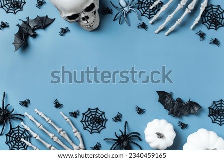 Halloween greeting card with pumpkin, skulls, bony hands and leaves