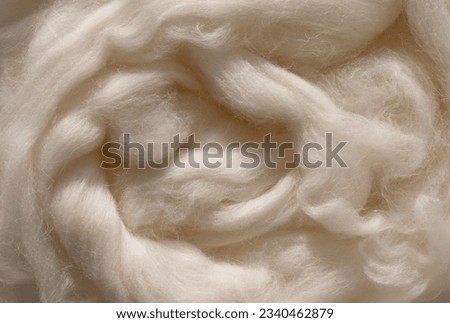Closeup woolen fiber in neutral beige color as background. Natural material in aesthetic sunlight. Royalty-Free Stock Photo #2340462879