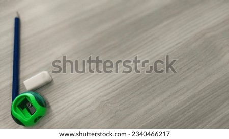 pencil eraser sharperner on the left of beige table