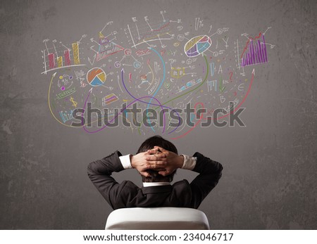 Young business man looking at sketches of graphs and symbols on the wall