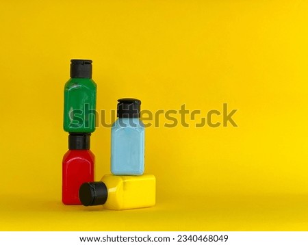 Bottles with bright multi-colored acrylic paint on a yellow background Royalty-Free Stock Photo #2340468049