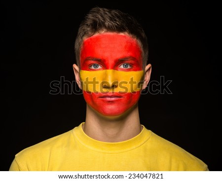 Flag of Spain painted on a face of a young man.