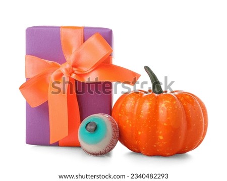 Tasty candy, pumpkin and gift box for Halloween on white background