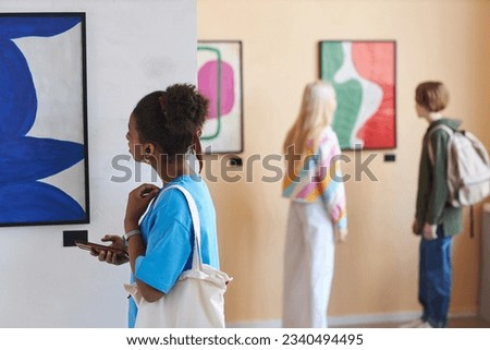 Colorful shot of diverse group of teenagers looking at art in modern art gallery or museum, copy space