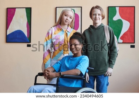 Colorful portrait of inclusive group of teenagers smiling at camera while visiting modern art gallery or museum together, copy space