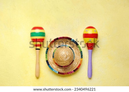 Mexican maracas with sombrero hat on yellow background Royalty-Free Stock Photo #2340496221