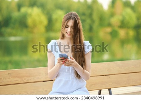 Young beautiful smiling hipster woman in white sundress using smartphone apps