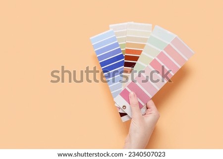 Hand with color palettes on beige background