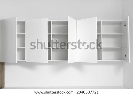 White cupboards hanging on light wall in kitchen Royalty-Free Stock Photo #2340507721