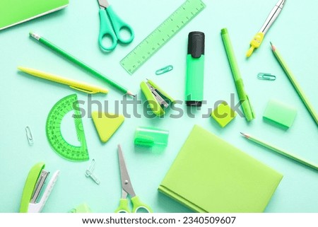 Different school stationery and notebook on turquoise background