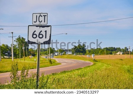 JCT 661 sign next to highway in summer with blue sky and thin clouds