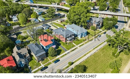 Aerial summertime suburban neighborhood in large city with suspended highway road Royalty-Free Stock Photo #2340513407