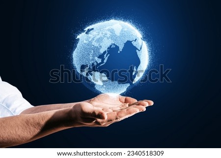 Close up of man hands holding glowing globe hologram on blurry blue background. Digital earth and metaverse concept