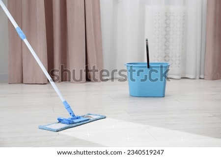 Washing floor with mop in room, space for text. Clean trace on dirty surface Royalty-Free Stock Photo #2340519247