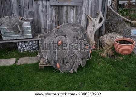        fisher net by a boatshouse                          Royalty-Free Stock Photo #2340519289