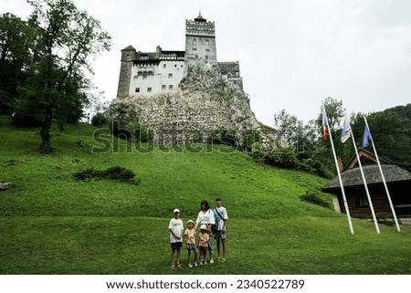 Family tourists against Bran Castle in Romania. Dracula medieval castle in Carpathians, Transylvania.