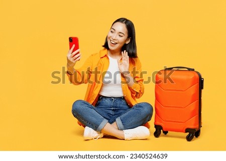 Young fun woman wear summer clothes sit suitcase do selfie shot mobile cell phone isolated on plain yellow background. Tourist travel abroad in free time rest getaway. Air flight trip journey concept