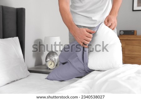 Man changing pillowcase at home, closeup. Domestic chores Royalty-Free Stock Photo #2340538027