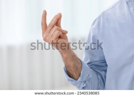 Man snapping his fingers indoors, closeup. Bad habit Royalty-Free Stock Photo #2340538085