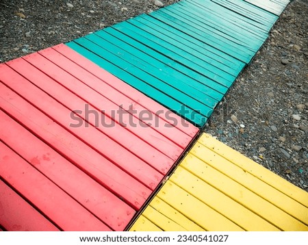 Colorful wooden path on a stony beach.