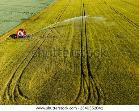 Aerial view of sprinkler system on a field with grain in summer, Germany