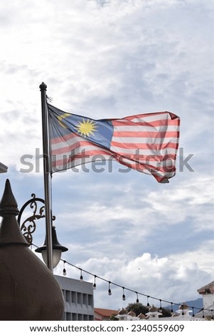 Malaysian Flag waving Independence Day  Merdeka Concept Blue sky and copy space. Royalty-Free Stock Photo #2340559609