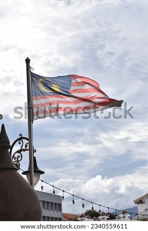 Malaysian Flag waving Independence Day  Merdeka Concept Blue sky and copy space. Royalty-Free Stock Photo #2340559611