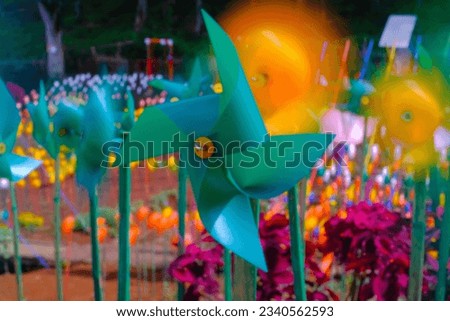 Zandea Pinwheel Park. Long Exposure shot Pinwheel Toy Landscape on Artificial Park. Colorful abstract art, plastic pinwheel, vibrant pinwheel, playful toy. Bandung - Indonesia. Royalty-Free Stock Photo #2340562593