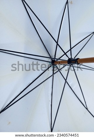 Open white umbrella. Umbrella frame with vintage pattern.