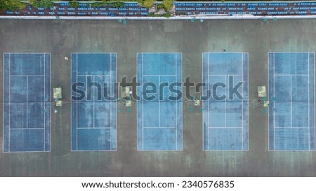 Arial View of Tennis courts in Batumi. 5 tennis sites from a height. People play tennis on the court from a height. Aero photo of the city with drone, background with Batumi. Traveling in Georgia, 
