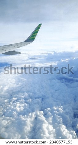 Through the airplane window, a breathtaking cloud image paints the sky, enhancing the beauty of the journey.