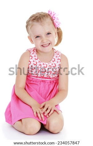 Cute little girl in a pink dress sitting on his knees clasped his hands in front of him .Isolated on white background.