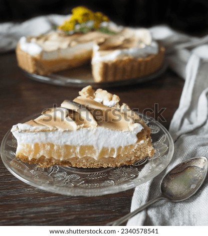 Slice of a lemon meringue tart on rustic table