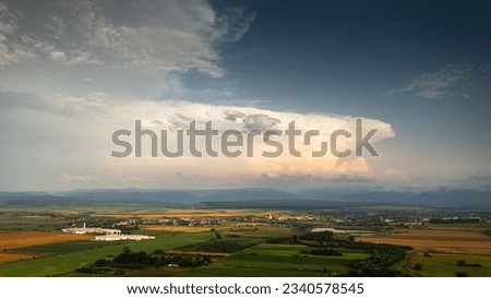 Massive cumulonimbus shelf cloud brings a big summer storm over hills landscape. Aerial photo.