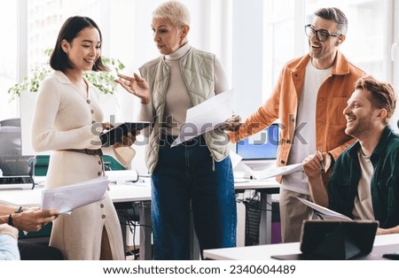 Diverse financial experts with paperwork communicate about business planning during working day in office interior,competitive male and female colleagues making cooperation brainstorming togetherness Royalty-Free Stock Photo #2340604489