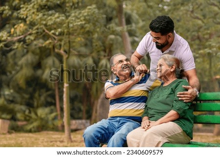 Young Indian man with his parents at park Royalty-Free Stock Photo #2340609579
