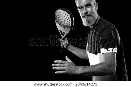 Old padel tennis player with racket. Man athlete with paddle tenis racket on court. Sport concept. Download a high quality photo for the design of a sports app or website.