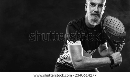 Old padel tennis player with racket. Man athlete with paddle tenis racket on court. Sport concept. Download a high quality photo for the design of a sports app or betting site.