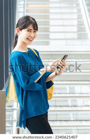 A woman using a smartphone with a smile.