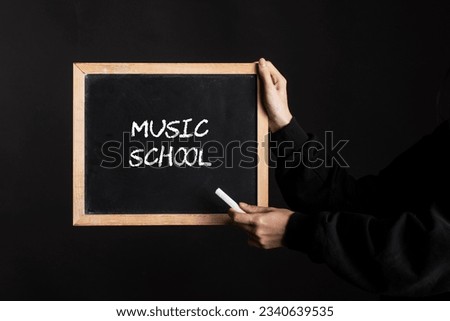 a blackboard sign with the word music school written on it