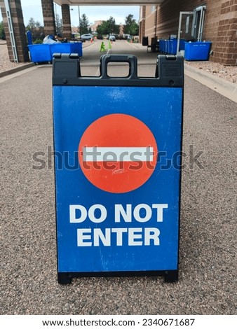 Do not enter stop sign on blue plastic portable folding sidewalk double sided sign stand on city street vertical photo. Access denied, closed path, forbidden enter, private property warning concept.