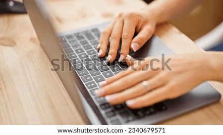 Young blonde woman using laptop sitting on table at office Royalty-Free Stock Photo #2340679571