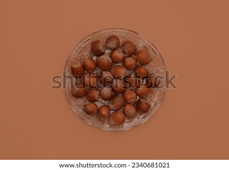 Close up of hazel nuts on glass plate with brown background