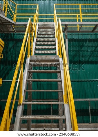 Industrial Interior, metallic colorful staircase with yellow railings Royalty-Free Stock Photo #2340688539